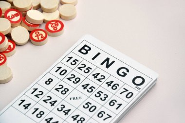 Masa başı bingo ya da loto oynamak için arka planda numaraları ve kartları olan bir sürü tahta fiş. Rus Lotosu 'nun dünya çapında klasik bingo oyunlarına benzer kuralları vardır..