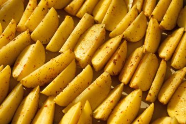 Patates kızartması, daha kalın dilimler halinde kesilmiş, otlar ve tuzla servis edilmiş. Arkaplan.