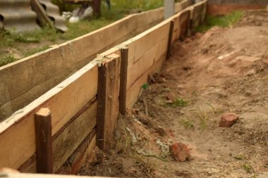 Wooden formwork concrete strip foundation for a veranda in a house. Outdoor construction work.