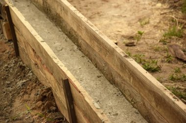 Wooden formwork concrete strip foundation for a veranda in a house. Outdoor construction work.