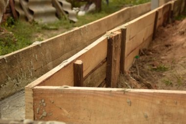 Wooden formwork concrete strip foundation for a veranda in a house. Outdoor construction work.