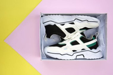 Bright female sneakers on pink-yellow background. Fashion blog or magazine concept. Flat lay top view copy space minimal background.