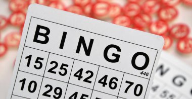 Masa başı bingo ya da loto oynamak için arka planda numaraları ve kartları olan bir sürü tahta fiş. Rus Lotosu 'nun dünya çapında klasik bingo oyunlarına benzer kuralları vardır..