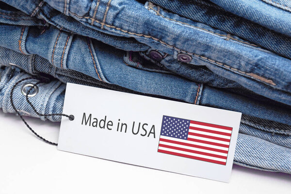 Синие джинсы, белая этикетка и лейбл Made in USA. Концепция покупки, продажи, шопинга и трикотажной современной одежды.
