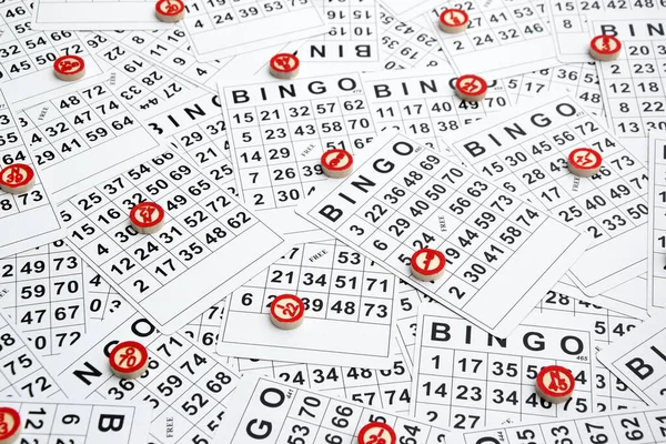 Many wooden chips with numbers and cards for a board game of bingo or lotto on a light background. Russian Lotto has similar rules to the classic worldwide bingo game.