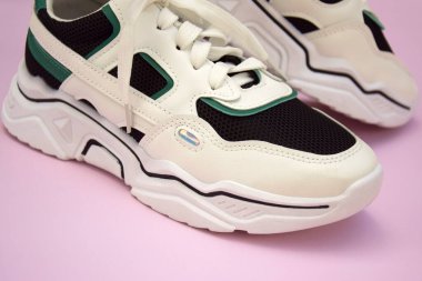 Bright female sneakers on light pink background. Fashion blog or magazine concept. Flat lay top view copy space minimal background.