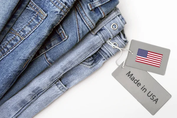 Detail of blue jeans, label and Made in USA lettering. The concept of buying, selling, shopping and trendy modern clothes.