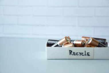 KHARKIV, UKRAINE - 22 Şubat 2022: Kullanılmış AA bataryalar ve çevresel ve toprak zehirli bataryaların mavi arka planda düzgün bir şekilde imha edilmesi. Zararlı ve geri dönüşümlü nesnelerin işlenmesi kavramı.