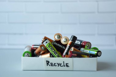 KHARKIV, UKRAINE - 22 Şubat 2022: Kullanılmış AA bataryalar ve çevresel ve toprak zehirli bataryaların mavi arka planda düzgün bir şekilde imha edilmesi. Zararlı ve geri dönüşümlü nesnelerin işlenmesi kavramı.