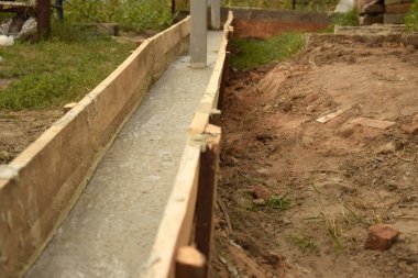 Wooden formwork concrete strip foundation for a veranda in a house. Outdoor construction work.