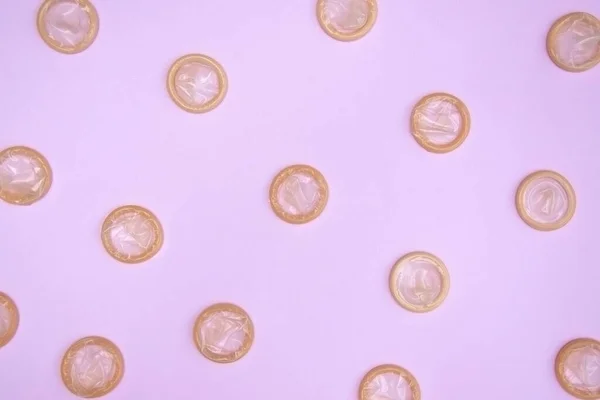 ピンクの背景に未開封のコンドームの多くの白いパッケージ 安全なセックスと生殖の健康の概念 — ストック写真