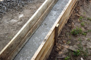 Wooden formwork concrete strip foundation for a veranda in a house. Outdoor construction work.