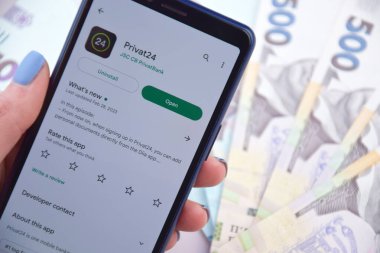 Kharkiv, Ukrayna - 13 Mart 2023: PrivatBank 'ın Ukrayna' daki mobil bankacılık uygulaması. Ulusal para birimi Hryvnia 'nın banknotlarından alınan özgeçmiş.