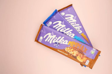 KHARKIV, UKRAINE - 12 Şubat 2023: Oreo aromalı çikolatalı Milka ve yumuşak pembe arkaplanda karamel.