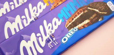 KHARKIV, UKRAINE - 12 Şubat 2023: Oreo aromalı çikolatalı Milka ve yumuşak pembe arkaplanda karamel.