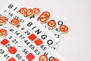 Masa başı bingo ya da loto oynamak için arka planda numaraları ve kartları olan bir sürü tahta fiş. Rus Lotosu 'nun dünya çapında klasik bingo oyunlarına benzer kuralları vardır..