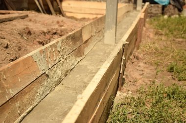 Wooden formwork concrete strip foundation for a veranda in a house. Outdoor construction work.