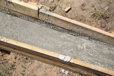 Wooden formwork concrete strip foundation for a veranda in a house. Outdoor construction work.