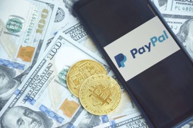 Kharkiv, Ukraine - October 7, 2022: PayPal logo on the screen smartphone with bitcoin cryptocurrency. Paypal is an internet based digital money transfer service.