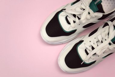 Bright female sneakers on light pink background. Fashion blog or magazine concept. Flat lay top view copy space minimal background.