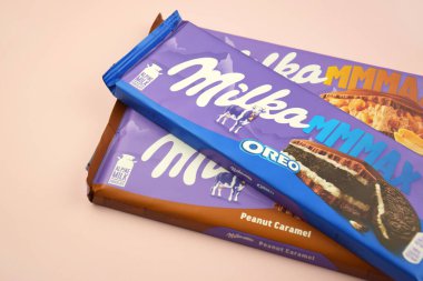 KHARKIV, UKRAINE - 12 Şubat 2023: Oreo aromalı çikolatalı Milka ve yumuşak pembe arkaplanda karamel.