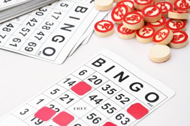 Masa başı bingo ya da loto oynamak için arka planda numaraları ve kartları olan bir sürü tahta fiş. Rus Lotosu 'nun dünya çapında klasik bingo oyunlarına benzer kuralları vardır..