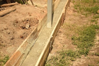 Wooden formwork concrete strip foundation for a veranda in a house. Outdoor construction work.