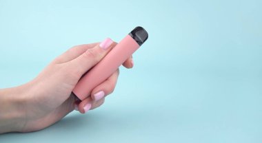 Mavi arka planda tek kullanımlık elektronik sigara seti. Modern sigara, buhar ve nikotin konsepti.