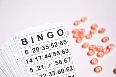 Masa başı bingo ya da loto oynamak için arka planda numaraları ve kartları olan bir sürü tahta fiş. Rus Lotosu 'nun dünya çapında klasik bingo oyunlarına benzer kuralları vardır..