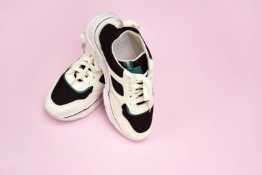 Bright female sneakers on light pink background. Fashion blog or magazine concept. Flat lay top view copy space minimal background.