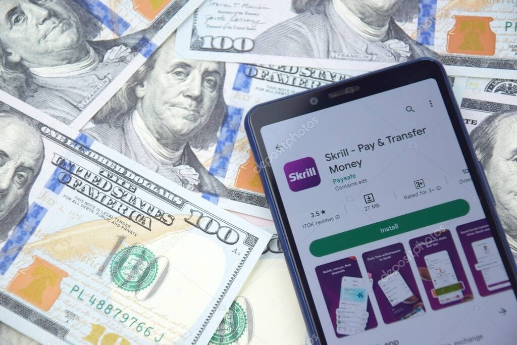 Kharkiv, Ukraine - March 13, 2023: Skrill mobile banking app on smartphone screen. Background from American dollar banknotes.