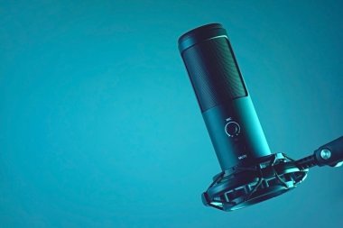 Studio condenser microphone isolated on dark background. The concept of vocals, streaming, podcast.