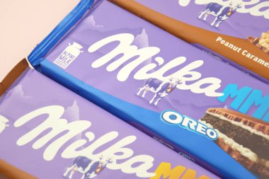 KHARKIV, UKRAINE - 12 Şubat 2023: Oreo aromalı çikolatalı Milka ve yumuşak pembe arkaplanda karamel.