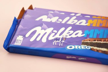KHARKIV, UKRAINE - 12 Şubat 2023: Oreo aromalı çikolatalı Milka ve yumuşak pembe arkaplanda karamel.