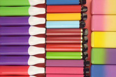 Kırmızı arka planda tek kullanımlık elektronik sigara seti. Modern sigara, buhar ve nikotin konsepti.