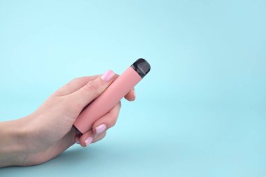 Mavi arka planda tek kullanımlık elektronik sigara seti. Modern sigara, buhar ve nikotin konsepti.