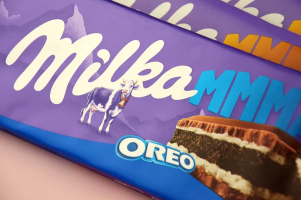 KHARKIV, UKRAINE - 12 Şubat 2023: Oreo aromalı çikolatalı Milka ve yumuşak pembe arkaplanda karamel.