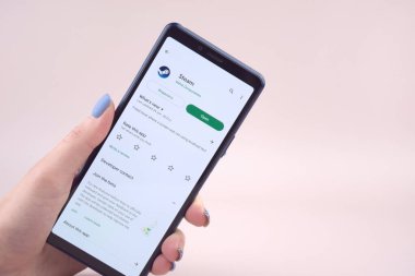 Kharkiv, Ukrayna, Mart 31, 2023: Video oyunu dağıtım platformunun logosuna sahip cep telefonu Vana tarafından web sayfası önünde ekranda çalıştırılıyor.