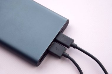 Mobil cihazları şarj etmek için güç bankası. Güç bankası olan siyah akıllı telefon şarj aleti. Mobil aygıtlar için dış pil.