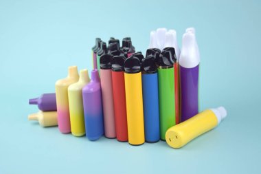 Mavi arka planda tek kullanımlık elektronik sigara seti. Modern sigara, buhar ve nikotin konsepti.