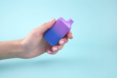 Mavi arka planda tek kullanımlık elektronik sigara seti. Modern sigara, buhar ve nikotin konsepti.