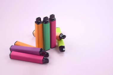 Pembe arka planda tek kullanımlık elektronik sigara seti. Modern sigara, buhar ve nikotin konsepti.