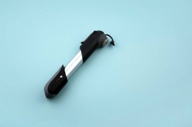 Mavi arka planda küçük bisiklet pompası.