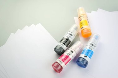 KHARKIV, UKRAINE - FEBRUARY 11, 2023: Four bottles of ink Epson, yellow, red, blue, black, built-in to the Epson L3150 series printer.