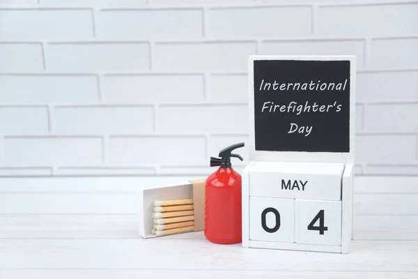 カレンダー5月4日と光の背景に消火器 消防士の国家世界の日を祝うという概念 — ストック写真