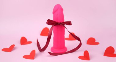 Pink dildo on light background with copyspace text for sex shop. The concept of sexual health.