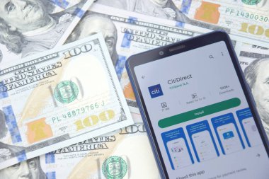 Kharkiv, Ukrayna - 13 Mart 2023: Akıllı telefon ekranında CitiDirect mobil bankacılık uygulaması. Amerikan dolar banknotlarının arka planı.