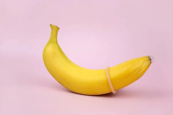 Презерватив Банан Розовом Фоне Крупным Планом Концепция Сексуального Здоровья — стоковое фото