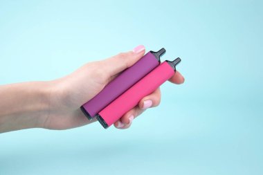 Mavi arka planda tek kullanımlık elektronik sigara seti. Modern sigara, buhar ve nikotin konsepti.