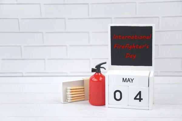 カレンダー5月4日と光の背景に消火器 消防士の国家世界の日を祝うという概念 — ストック写真